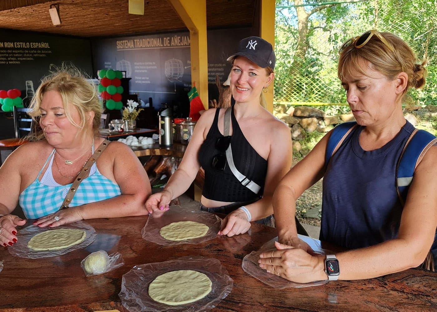 Guests pressing fresh tortillas at a table during a farm visit